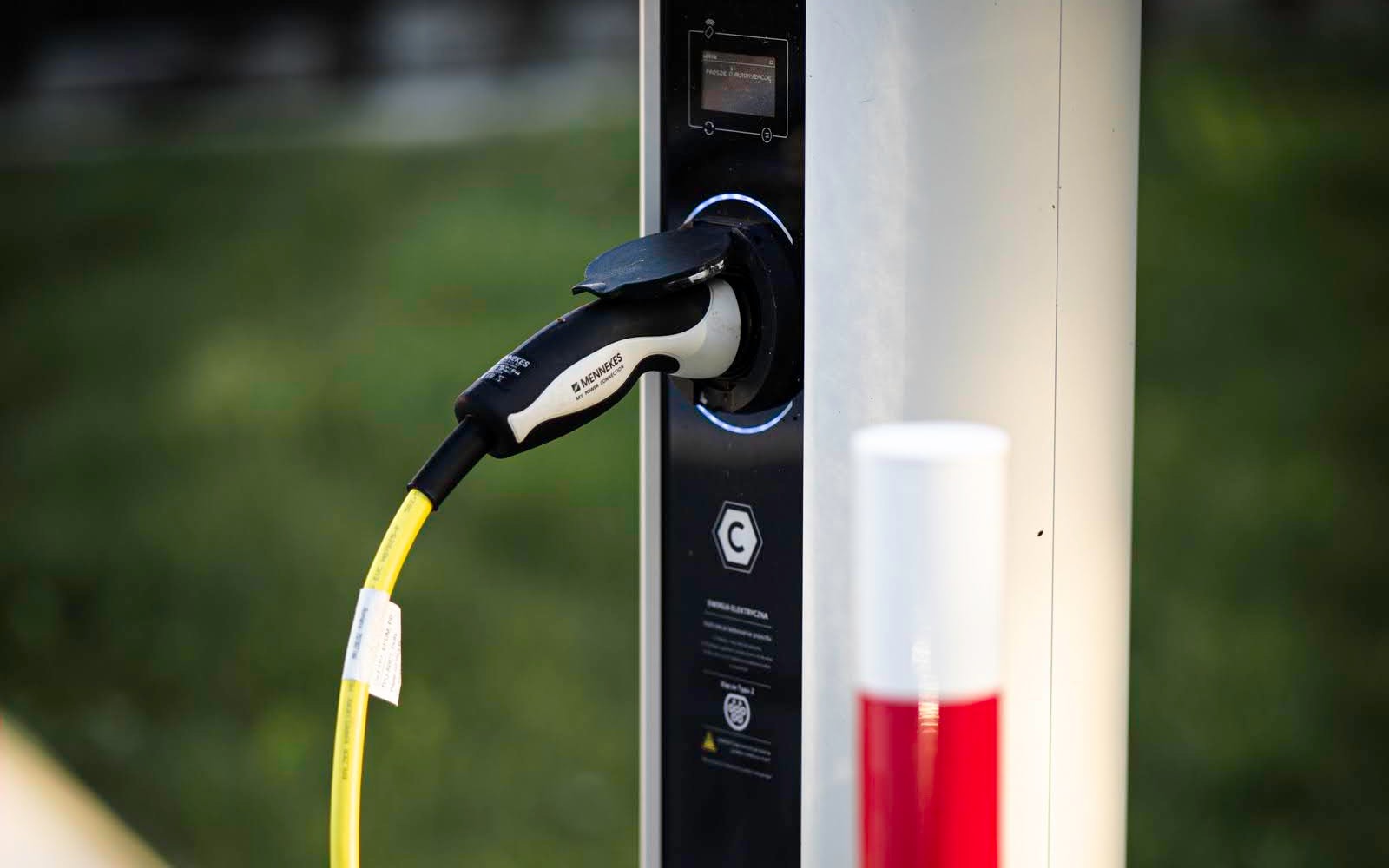 Samochód elektryczny ładowany na osiedlu mieszkaniowym