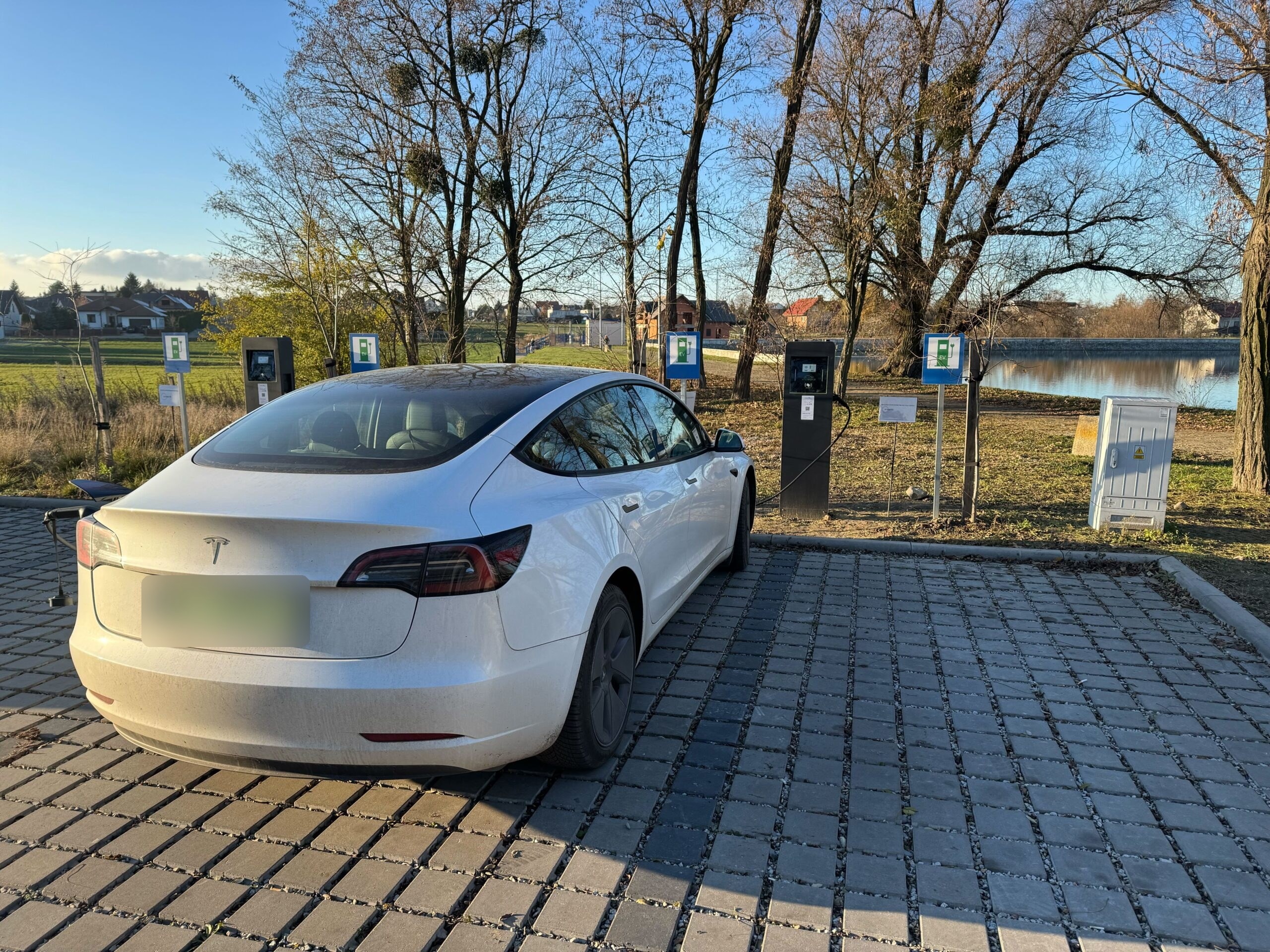Samochód elektryczny przy współdzielonych stacjach ładowania na osiedlowym parkingu